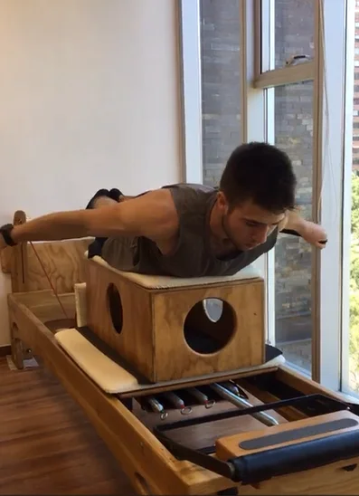 Hombre sosteniendo una plancha sobre el cajón de un Reformer