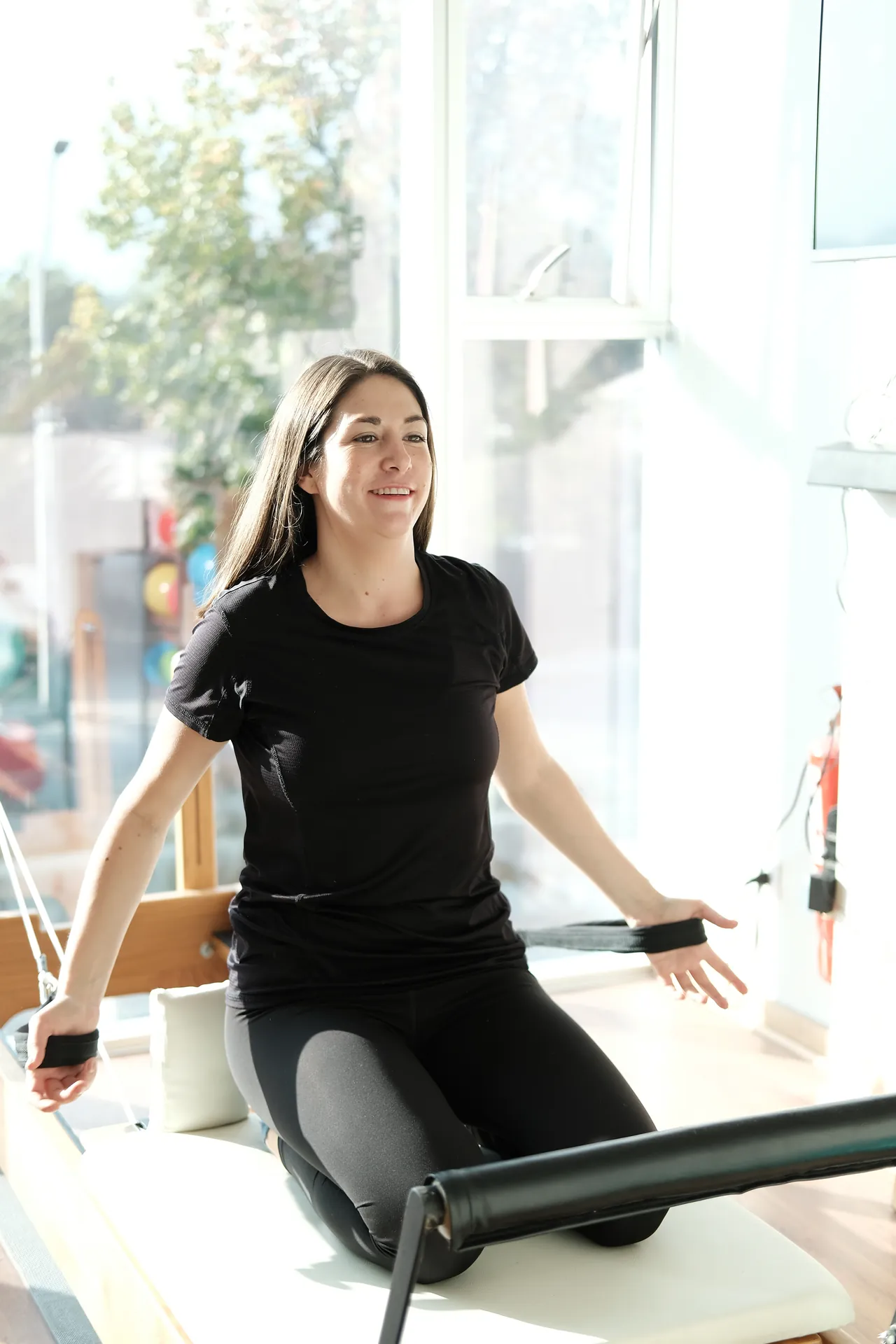 Instructora de VivePilates trabajando con las correas del Reformer